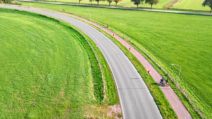 Aerial drone view of asphalt motorway road curve and bicycle lane from above, transportation infrastructure of the Netherlands