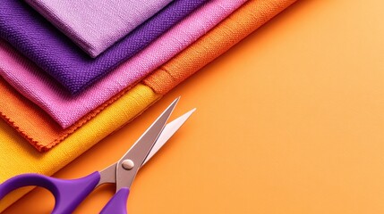 Colorful fabrics stacked neatly with scissors on an orange background, ideal for crafting projects