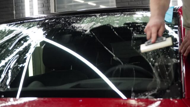The process of installing the protection film on the windshield of a car. PPF is a paint protection film that protects paint from scratches and gravel. Athermal film on the windshield of the car.