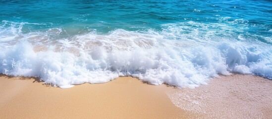 Gentle ocean waves crashing on sandy beach under bright blue sky