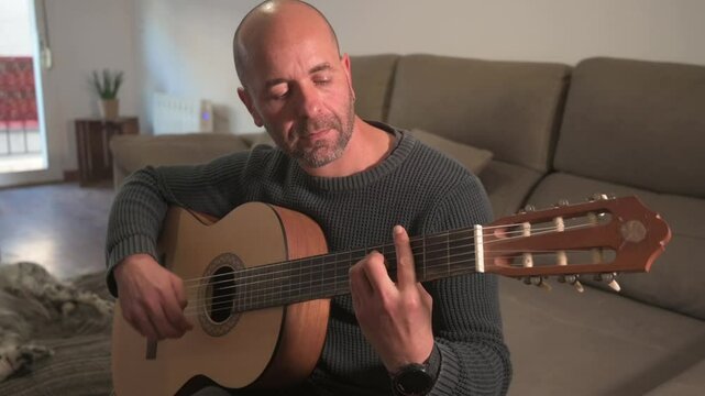 Musician playing spanish guitar at home