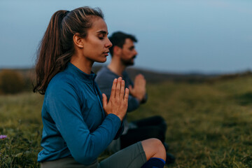 Athletes practicing yoga in nature at sunset: finding inner peace and harmony