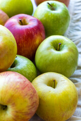 Apples of different varieties such as Granny Smith, Starking, Fuji are on the table