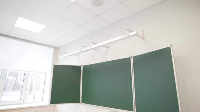 Modern classroom shows modern board and lamp mounted above on wall. Bright learning area ready for future students coming to study