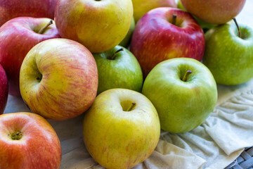 Apples of different varieties such as Granny Smith, Starking, Fuji are on the table