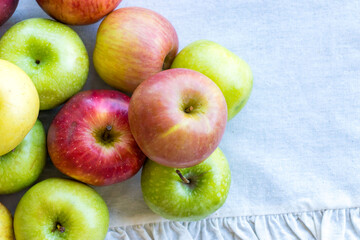 Apples of different varieties such as Granny Smith, Starking, Fuji are on the table
