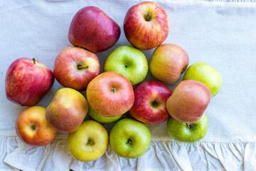 Apples of different varieties such as Granny Smith, Starking, Fuji are on the table