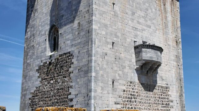Castle of beja stone tower with battlements against a vibrant blue sky