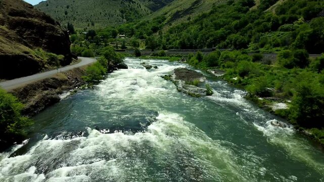 US, Oregon, Maupin, Baxter Rapids, 2025-05-08 - Drone view over the Deschutes River in Spring with a railroad line and green trees in north central Oregon