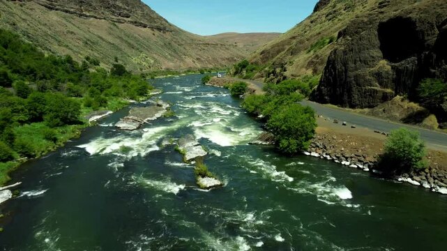 US, Oregon, Maupin, Baxter Rapids, 2025-05-08 - Drone view over the Deschutes River in Spring with a railroad line and green trees in north central Oregon