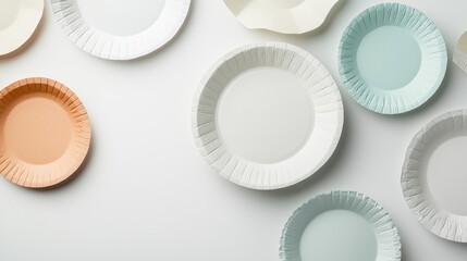 Collection of white paper plates arranged in a scattered manner on a light grey background. there are nine plates in total, each with a unique design and color.