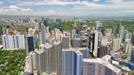 Drone gently descends over the business district of Makati, capturing the vertical scale of the towers and the dense city structure under bright midday sun in Metro Manila, Philippines. - Powered by Adobe