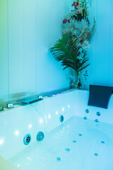 Fototapeta premium Close up of a modern hydromassage bathtub with blue light, jets and decorations, providing a relaxing spa experience