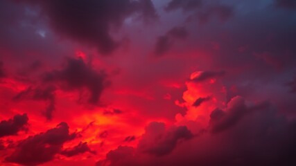 Dramatic crimson sky and dark clouds illuminated by the fiery glow of the sunset