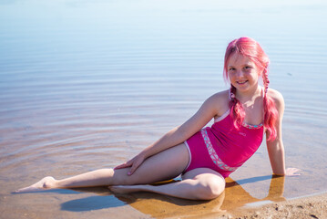 A girl with pink hair is relaxing on a lake on a hot summer day.