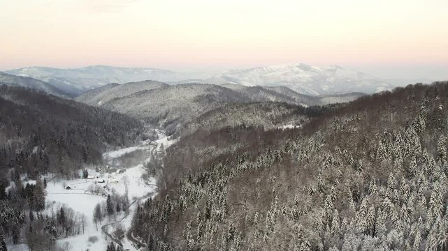 Winter landscape in Goc, Serbia showcases snow-covered mountains and serene valleys at dusk
