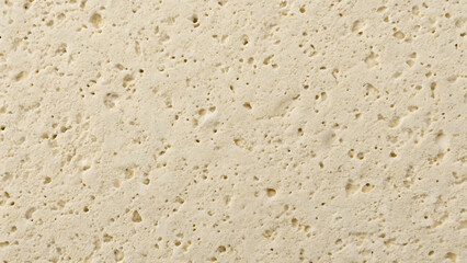 Closeup texture of light beige porous material with irregular holes