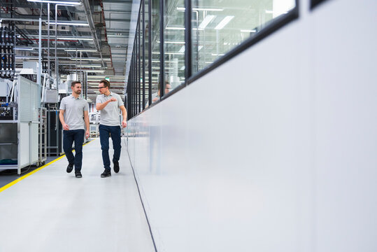 Employees walking and discussing in a modern production hall