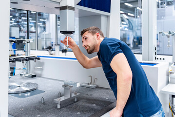 Employee inspecting precision tools in an industrial factory