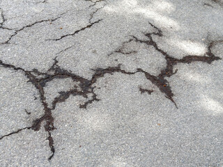 Cracked asphalt surface with visible damage and texture detail