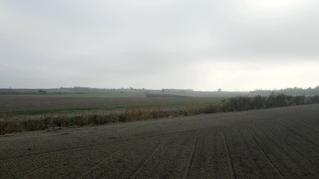 Exploring the serene landscapes of Kac Serbia during a foggy day with distant fields and muted colors