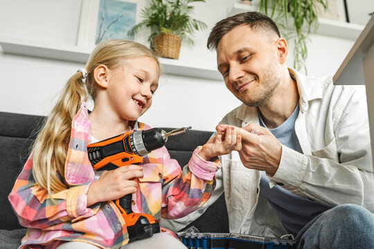 Father and daughter assembling furniture together at home
