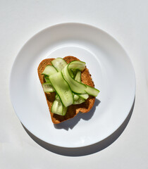 tost with cucumber slices on white plate