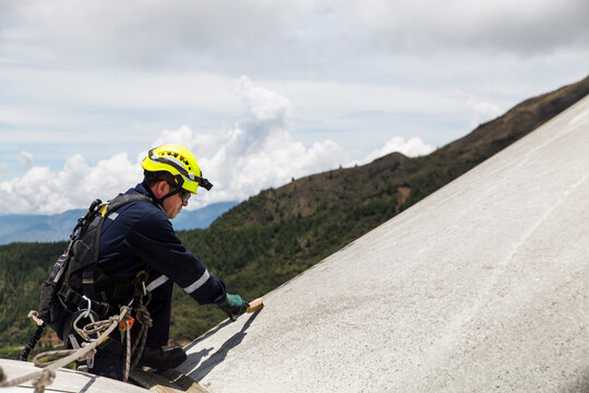 Engineer inspecting nacelle on wind turbine rooftop outdoors