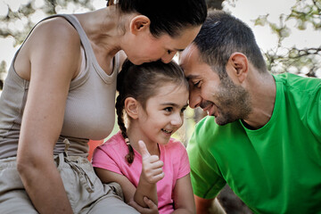 Fototapeta premium Happy family bonding moment in nature with smiling child showing thumbs up