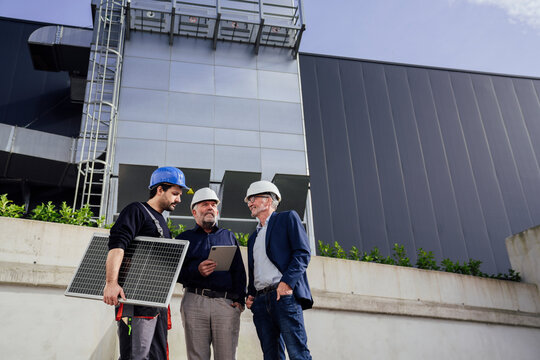 Engineers discussing solar panel installation outdoors