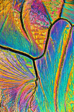 Microscope view of vibrant salicylic acid crystals with colorful abstract patterns