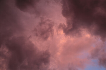 Fiery red storm clouds with dramatic lighting. Red storm clouds background. Dramatic red sky.