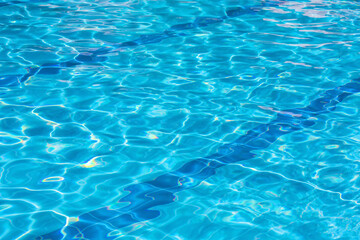 Clear blue swimming pool with sunlight reflections and ripple effect, vibrant aquatic texture for summer and leisure themes