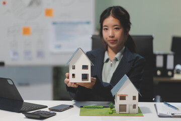 Real estate agents explain models of housing estates in projects to elaborate to clients,...