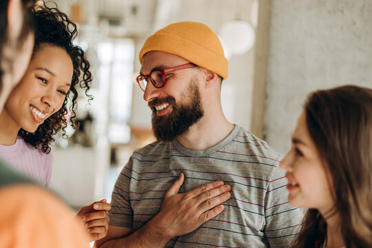 Grateful man expressing gratitude with hand on chest to startup team