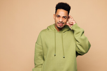 Young sad man of African American ethnicity wear green hoodie casual clothes put hand on head...