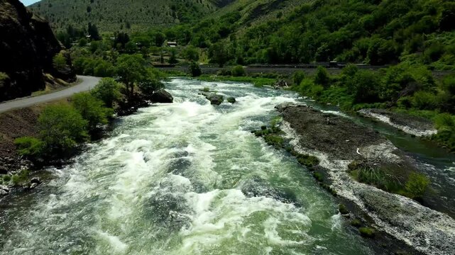 US, Oregon, Maupin, Baxter Rapids, 2025-05-08 - Drone view over the Deschutes River in Spring with a railroad line and green trees in north central Oregon