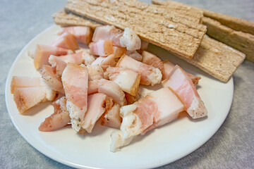 Cuisine Concepts. Traditional Sliced Ukrainian Salo Served With Dried Slices of Bread Top view Against Rustic Wooden Table Background