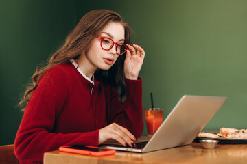 Focused freelancer working remotely in cafe, enjoying pizza and drink