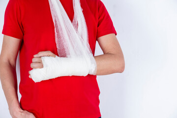 Medical Concepts. Closeup of Body Parts of Caucasian Man in Red Shirt with Broken Hand In Plaster and Bandaid Isolated on White Background.