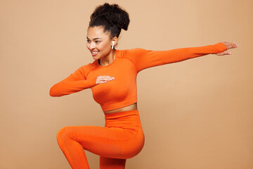 Young strong fitness trainer instructor sporty woman sportsman wear orange clothes spend time in...
