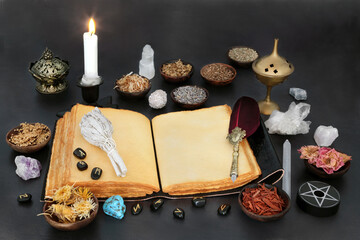 Witches magical equipment with book of spells, herbs, runes and crystals for occult esoteric healing purposes. Ancient witchcraft for natural alternative medicine.