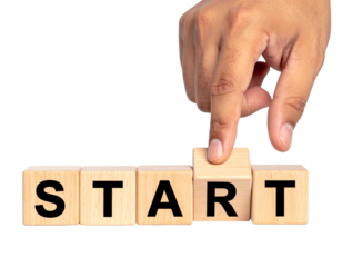 A hand presses a wooden block among others spelling out the word "START".
