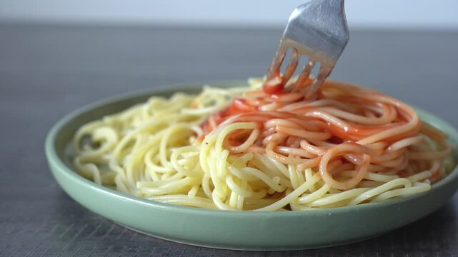 Spaghetti and ketchup, close-up.  Spaghetti with ketchup in a green plate.