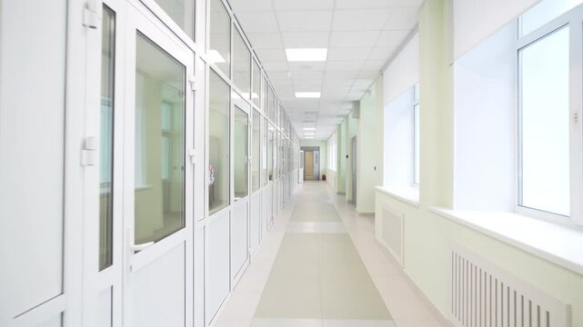 Bright long corridor with daylight and modern minimalist design with large windows. Clean modern interior features white walls and doors