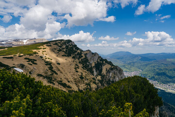 Bucegi Mountains plateau in Romania, showing a vast alpine landscape with scattered patches of snow...