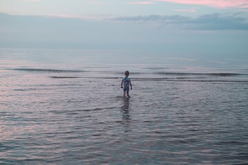 boy walks deep to the water