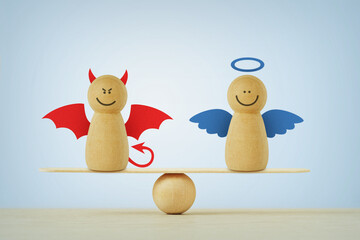 Devil and angel wooden pawn on balance scale - Balance between good and evil