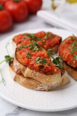 Tasty bread with tomatoes and parsley on white marble table, closeup