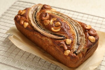 Delicious banana bread with nuts on light table, closeup